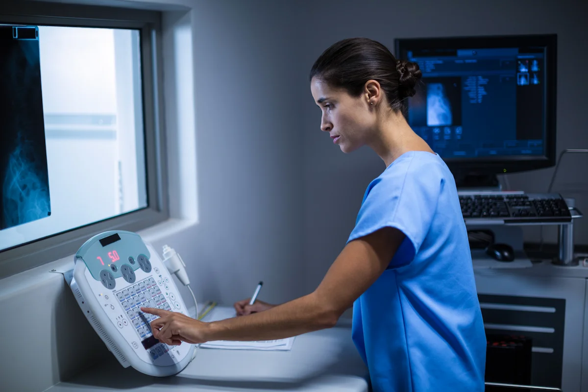 tecnico radiologista operando um aparelho para realizacao de exame de imagem